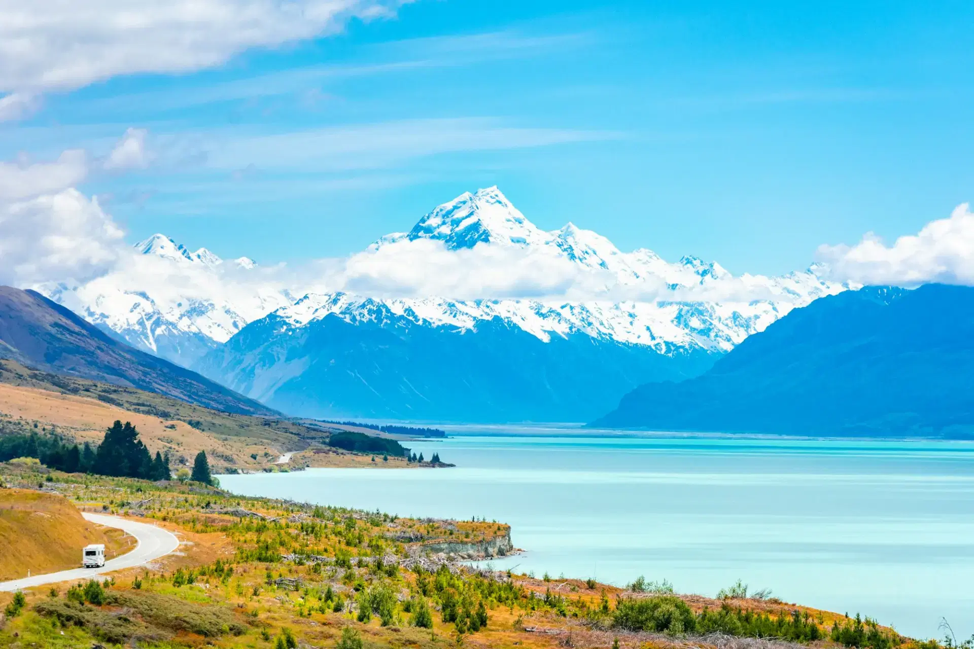 Green meadow and lake in front of snow-covered Aoraki / Mount Cook