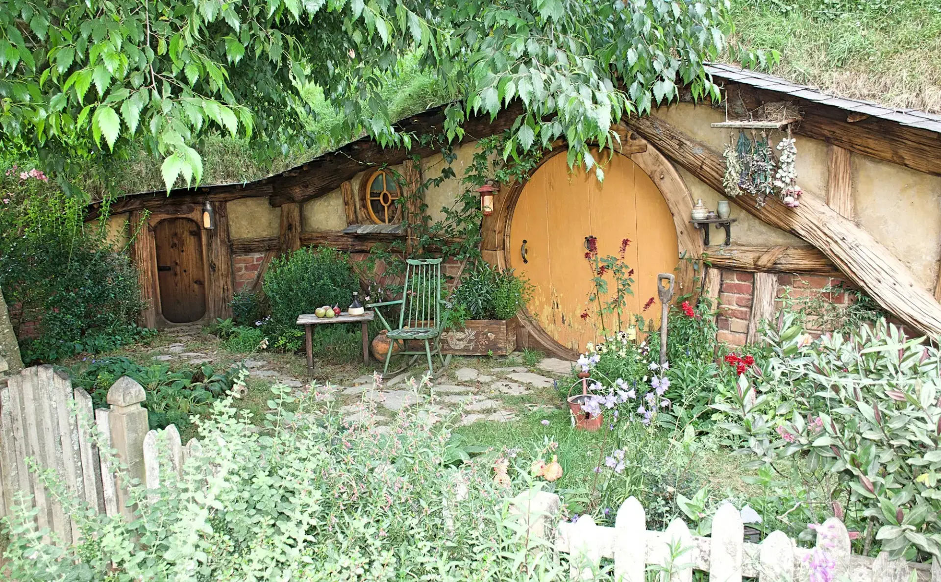 Round green door of a hobbit hole set into a grassy hill